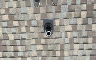 Rooftop shingle pattern with a black vent pipe centered near the top