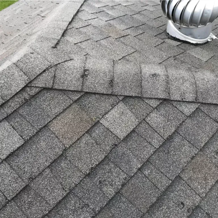 Gray shingled rooftop with a silver vent pipe near the top right