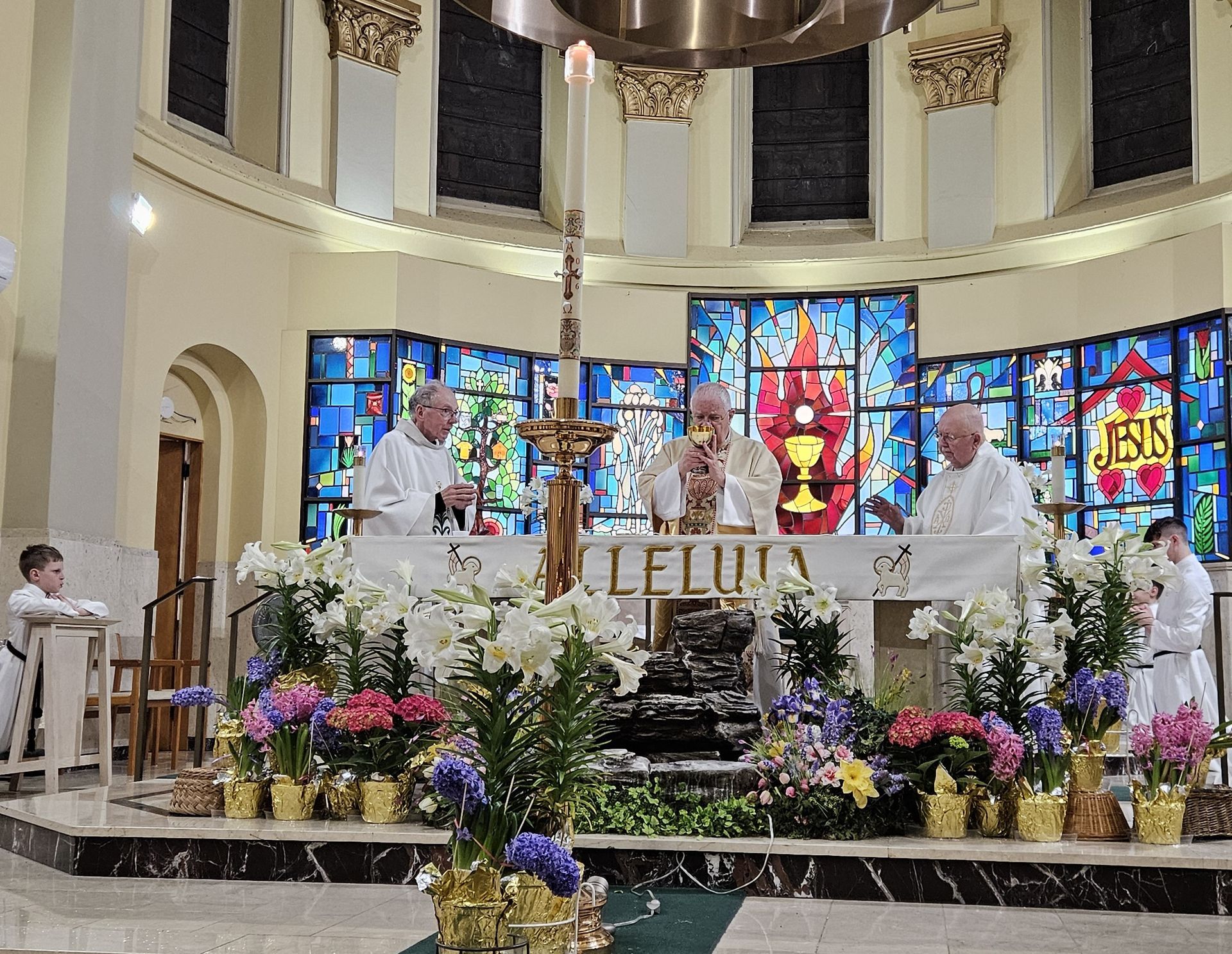 Three OMI members celebrate Mass behind an altar decorated with 