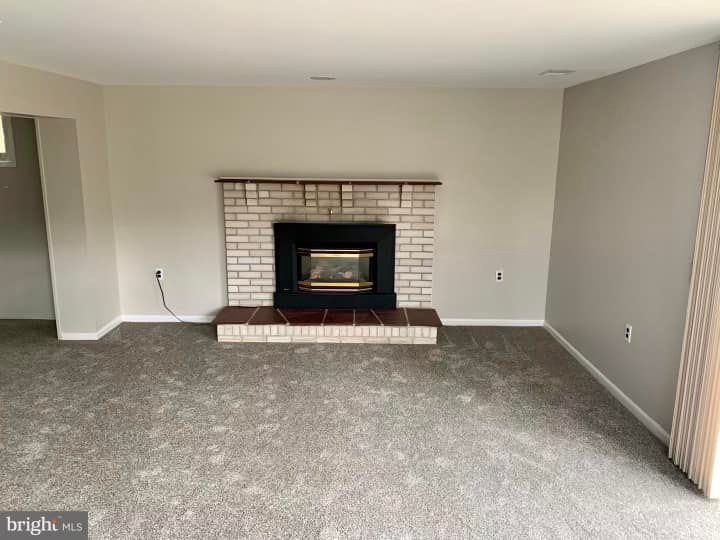 There is a fireplace in the middle of the living room.
