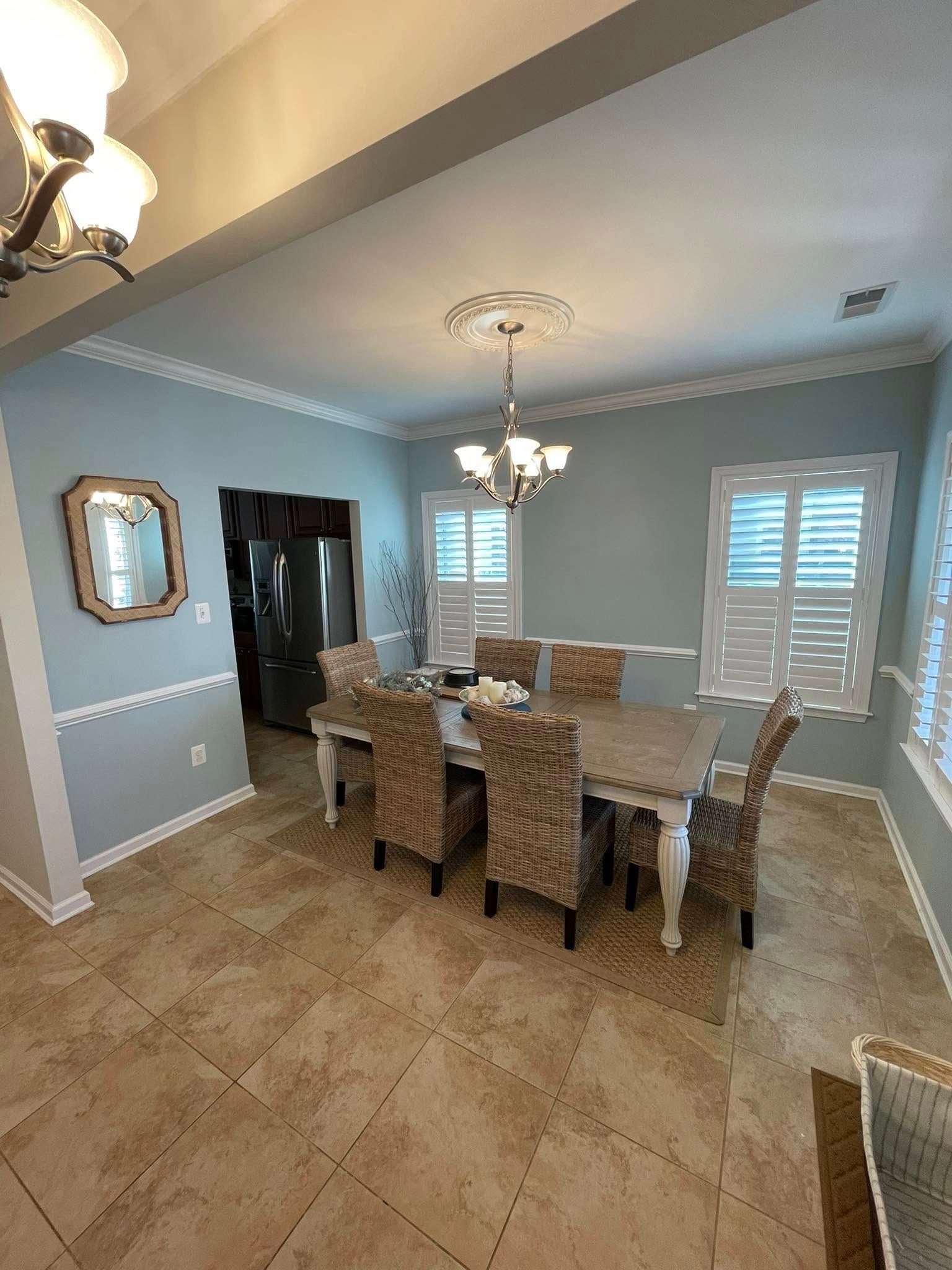 A dining room with a table and chairs and a chandelier.