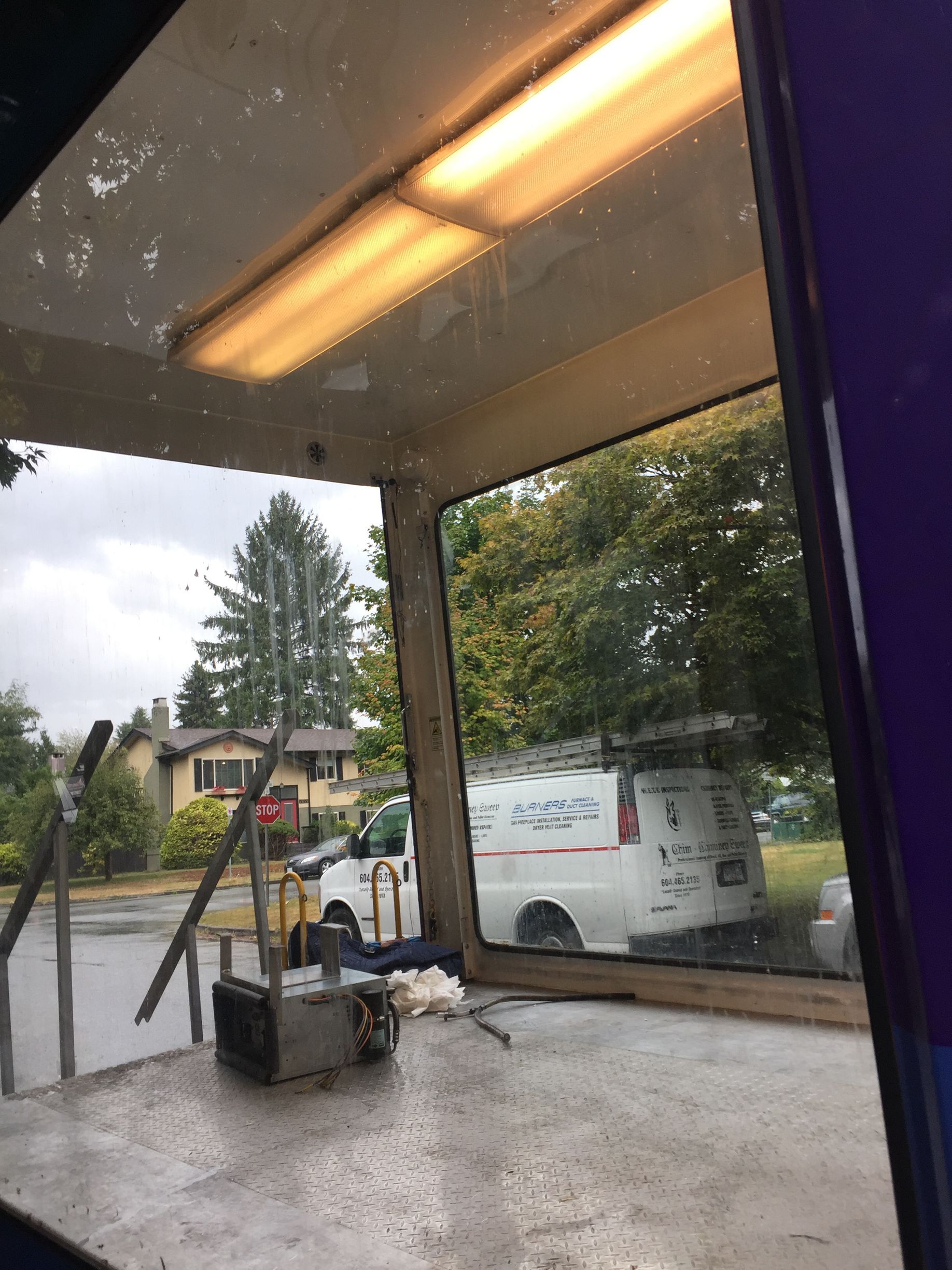 A white van is parked in a parking lot in front of a building.