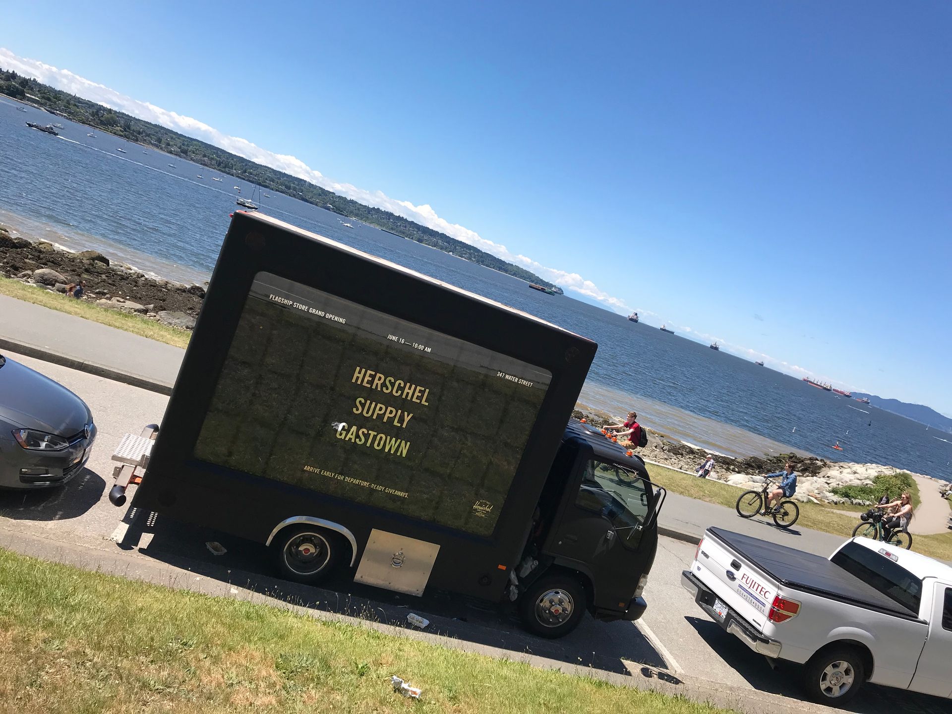 A truck with a large screen on it is parked on the side of the road.
