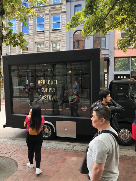 A black truck is parked on the side of the road in front of a building.