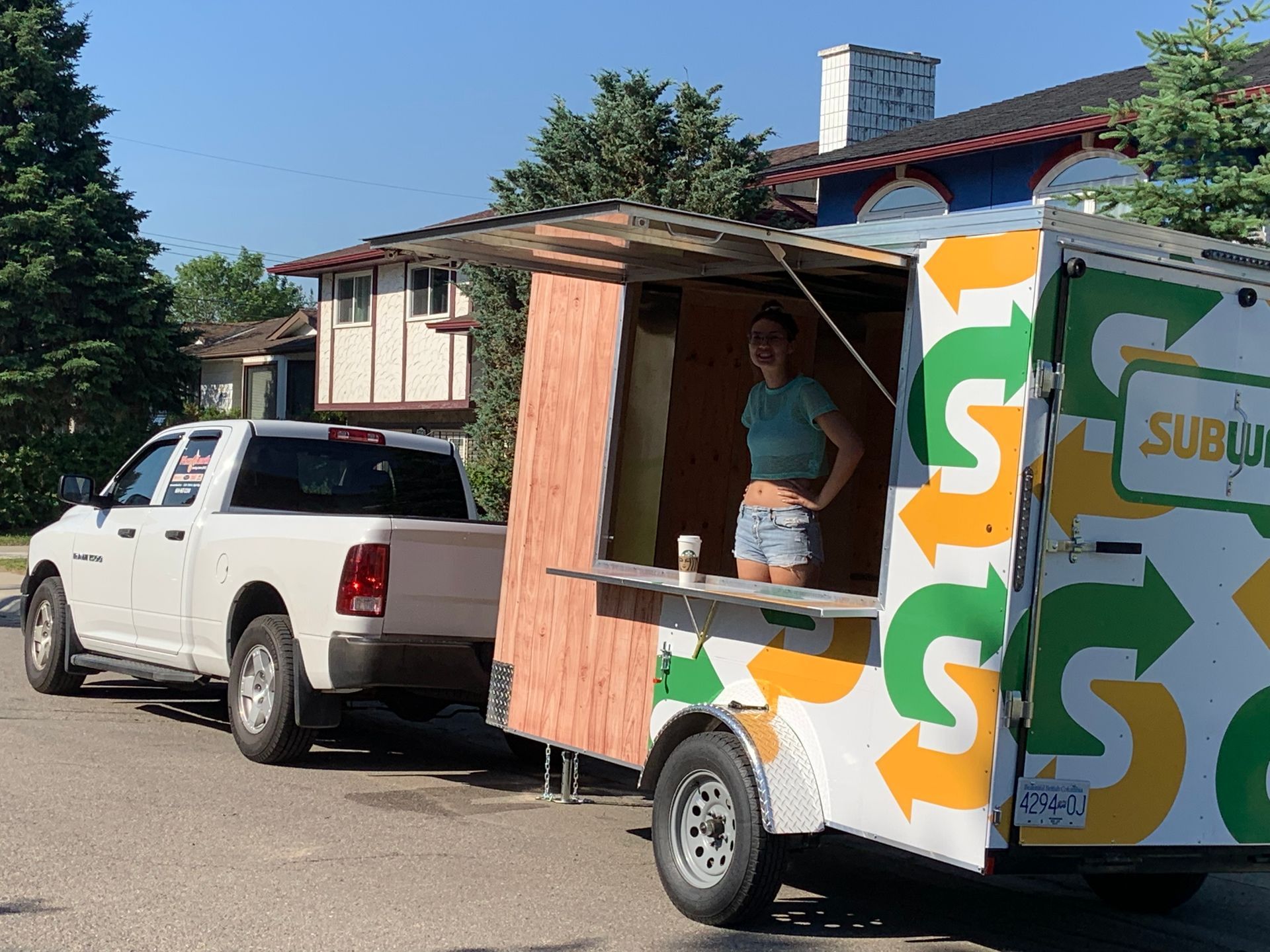 A woman is standing in front of a subway food truck