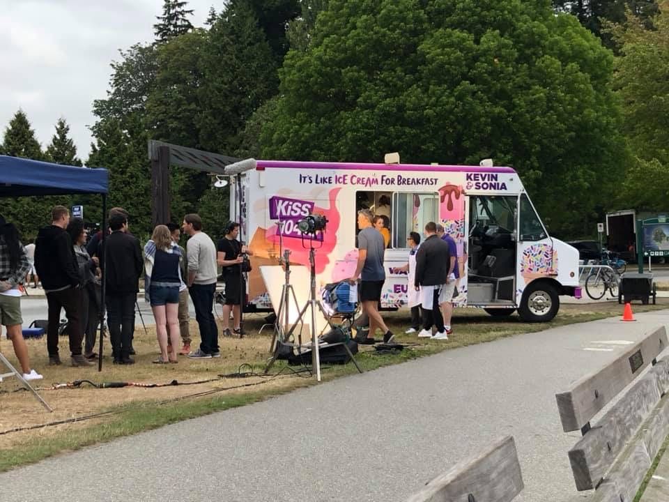 A group of people are standing in front of an ice cream truck.