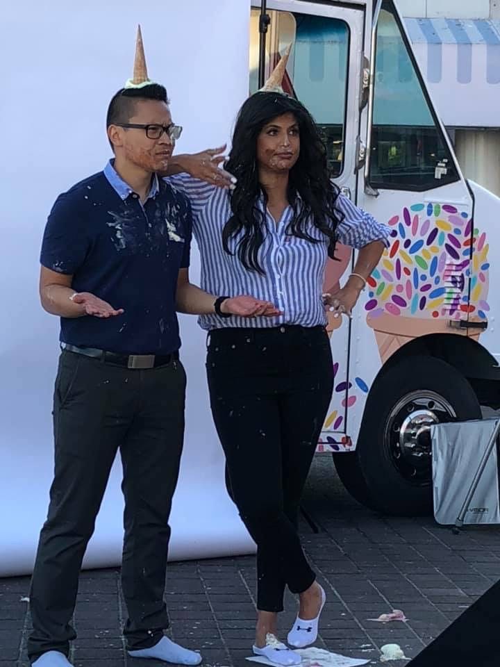 A man and a woman are standing in front of an ice cream truck