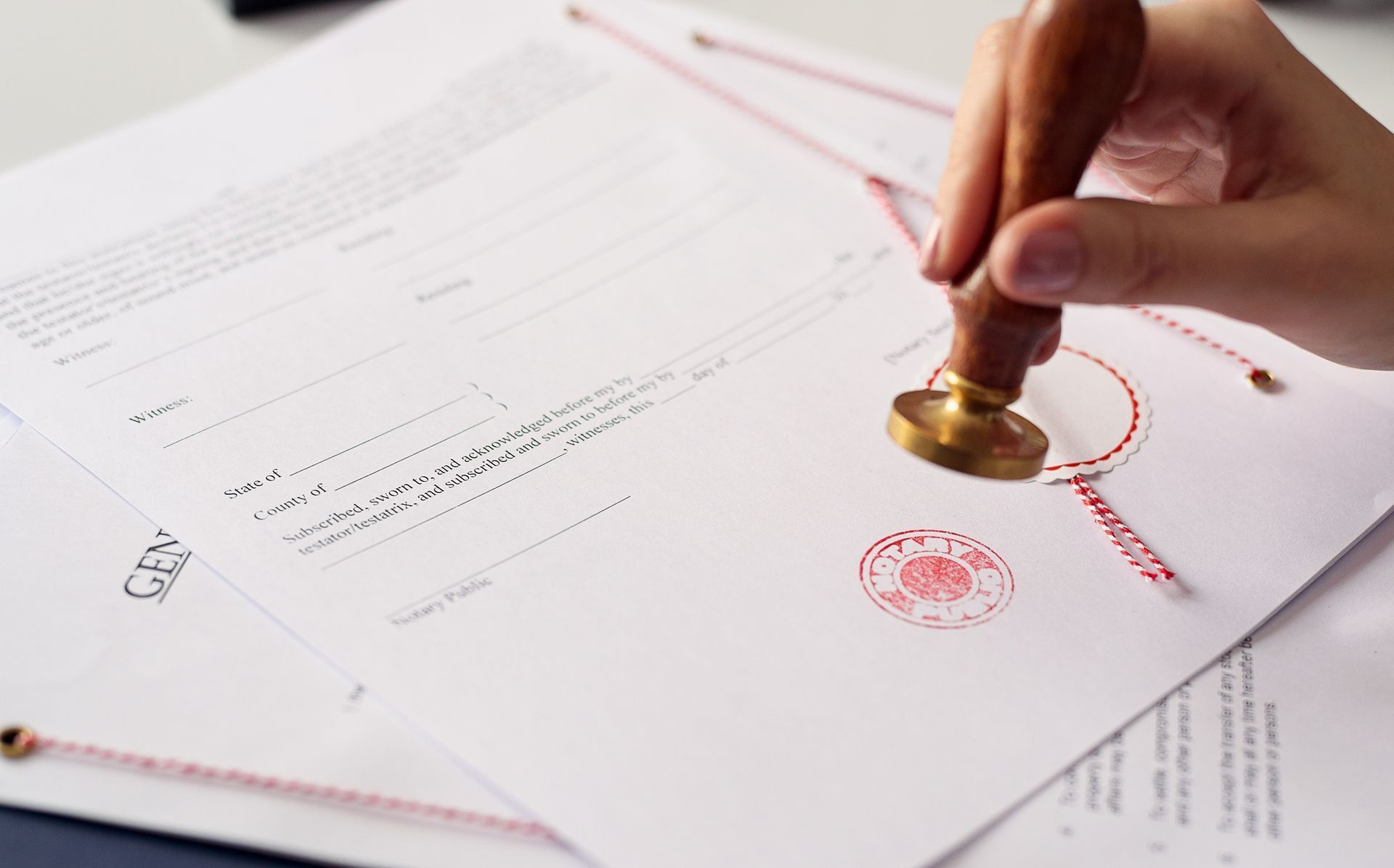 a person is stamping a document with a wax seal .