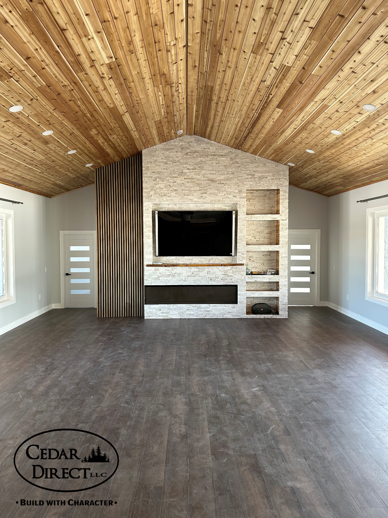 A living room with a wooden ceiling and a flat screen tv.