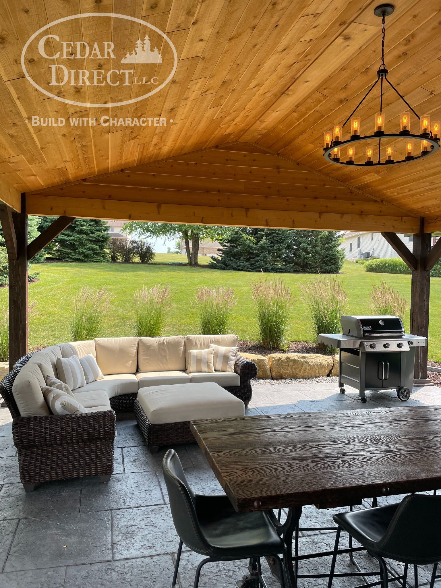 A patio with a table , chairs , a couch and a grill.