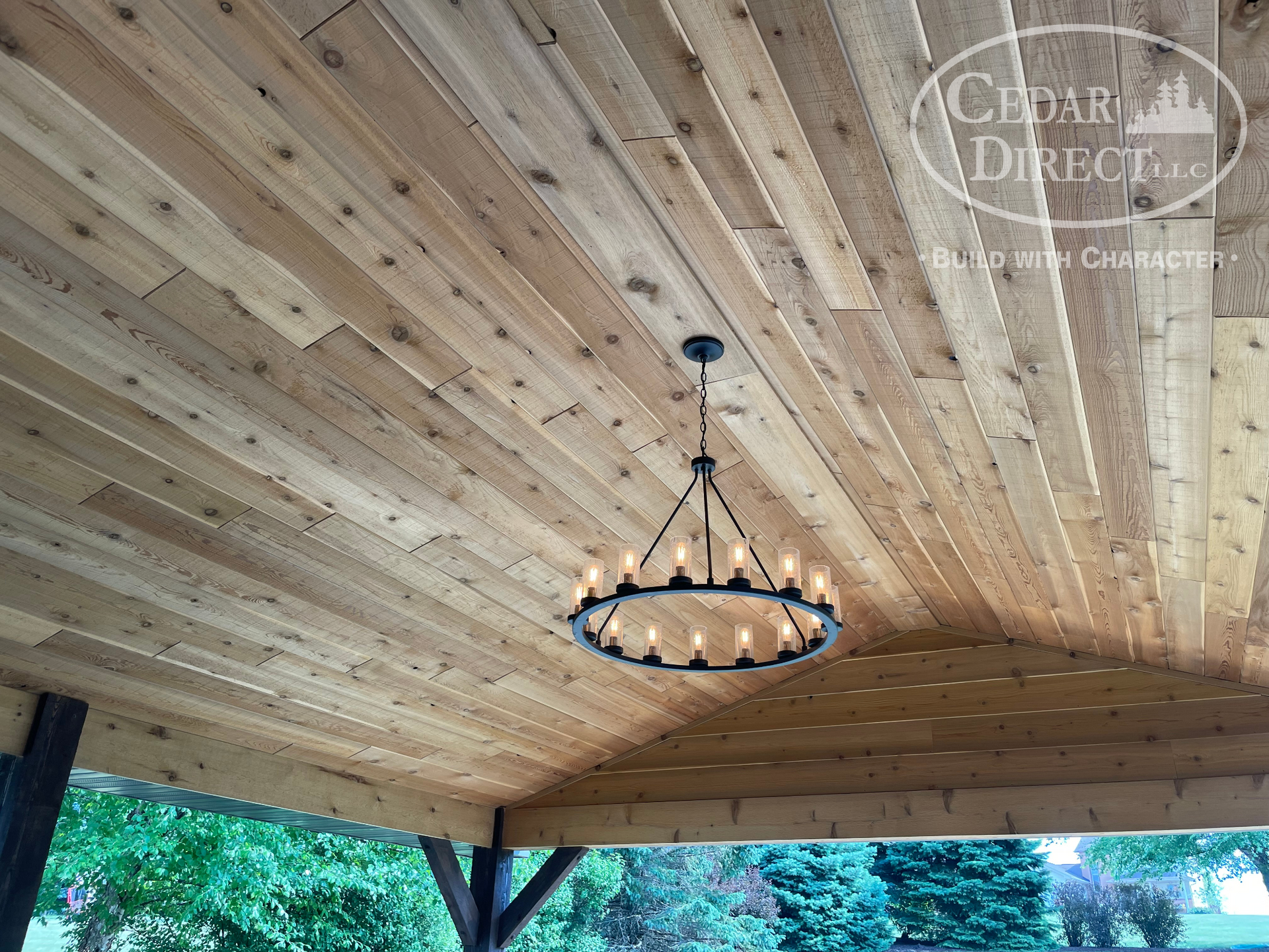 A wooden ceiling with a chandelier hanging from it.