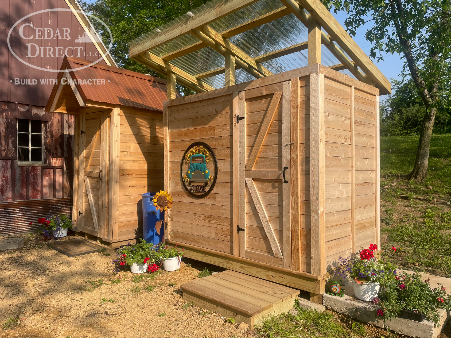 A wooden shed with a glass roof is sitting next to a barn.