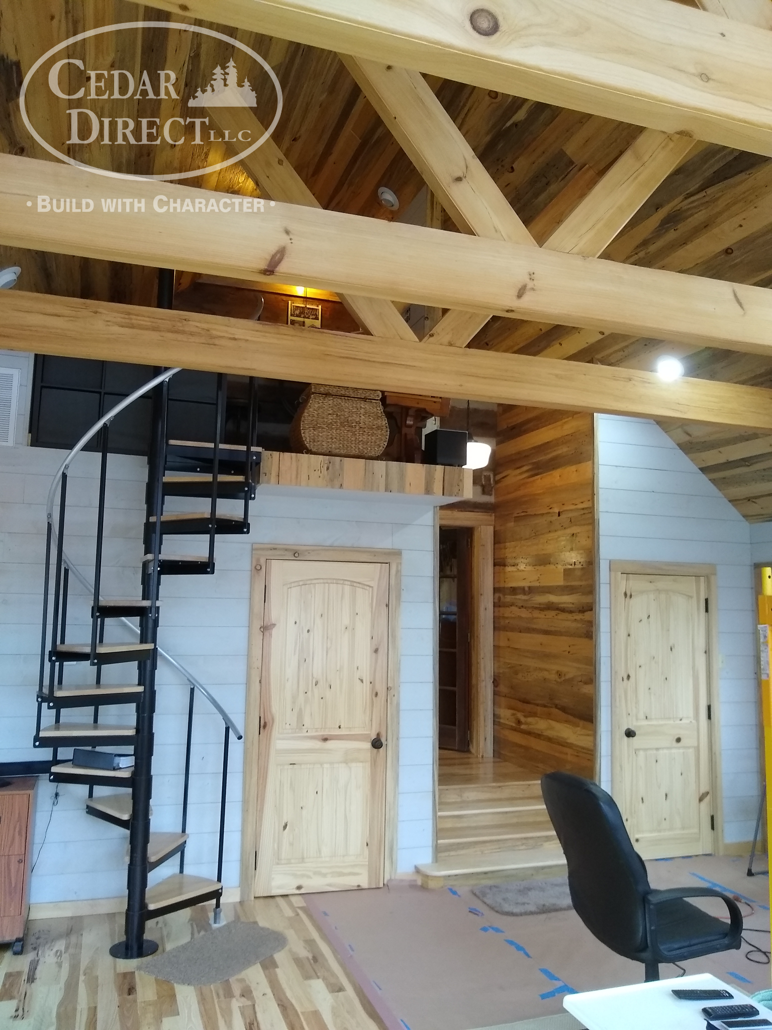 A wooden cabin with a spiral staircase and a chair
