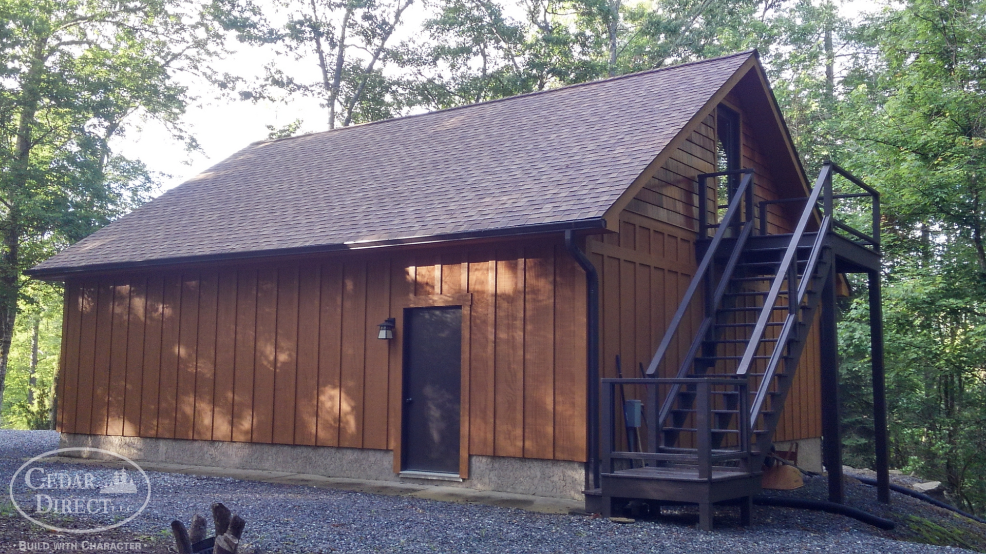 A small wooden house with stairs leading up to the second floor.