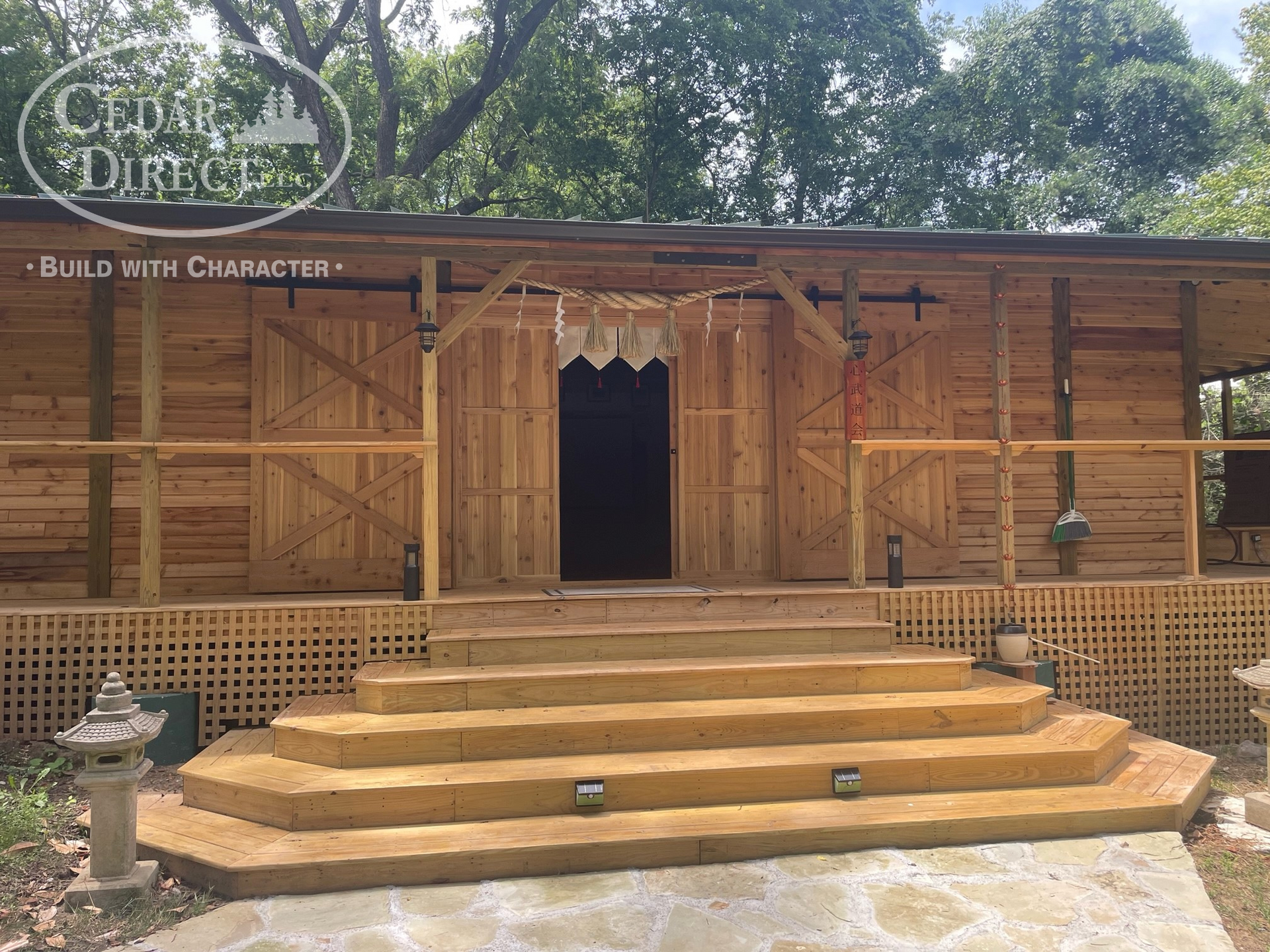 A wooden house with stairs leading up to the front door.