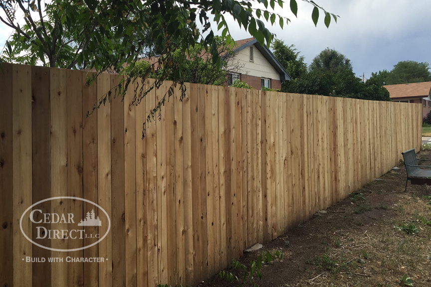 A wooden fence with a cedar direct logo on it