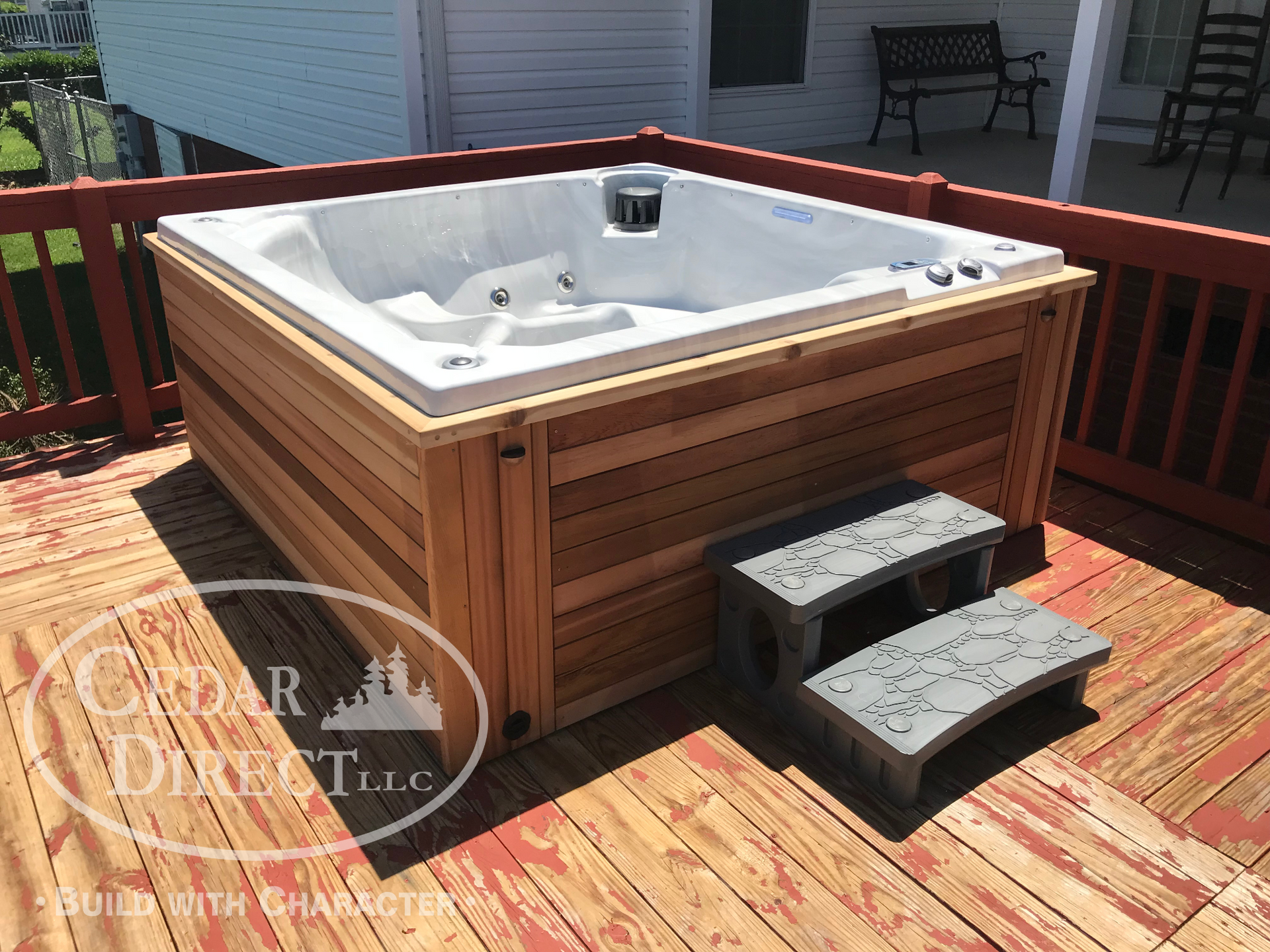 A white hot tub is sitting on a wooden deck