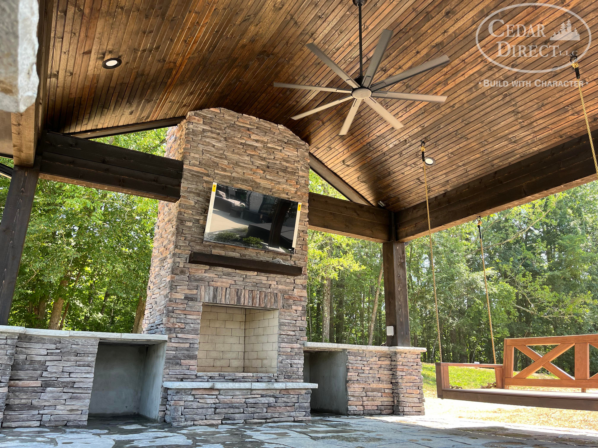 There is a ceiling fan hanging from the ceiling above the fireplace.