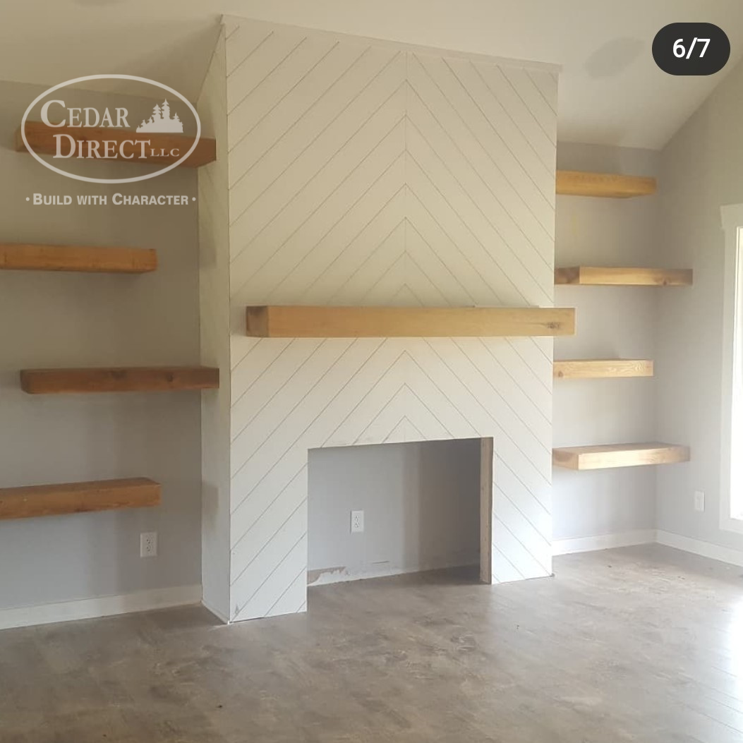 A living room with a fireplace and shelves built by cedar direct