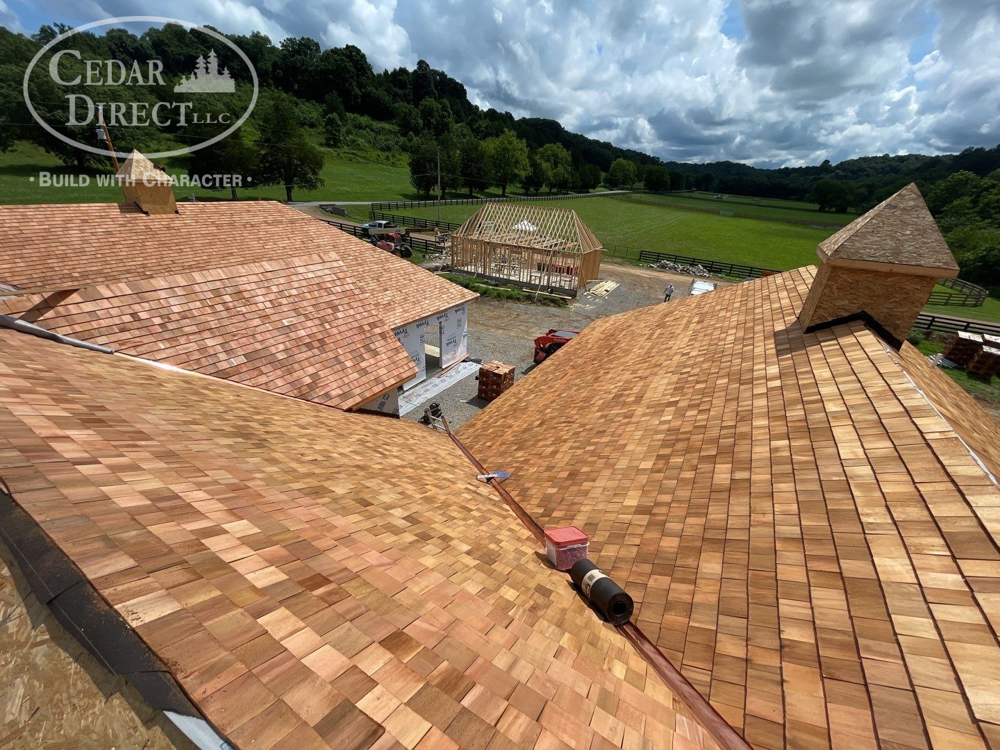 An aerial view of a wooden roof with a field in the background.