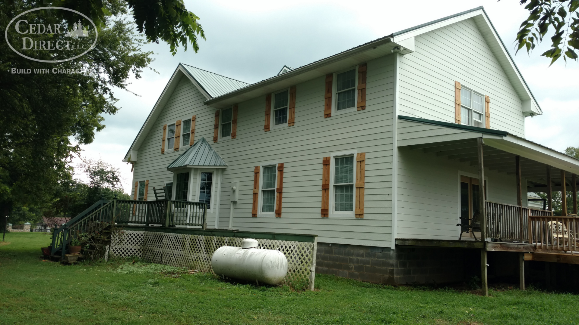 A large white house with a propane tank in front of it