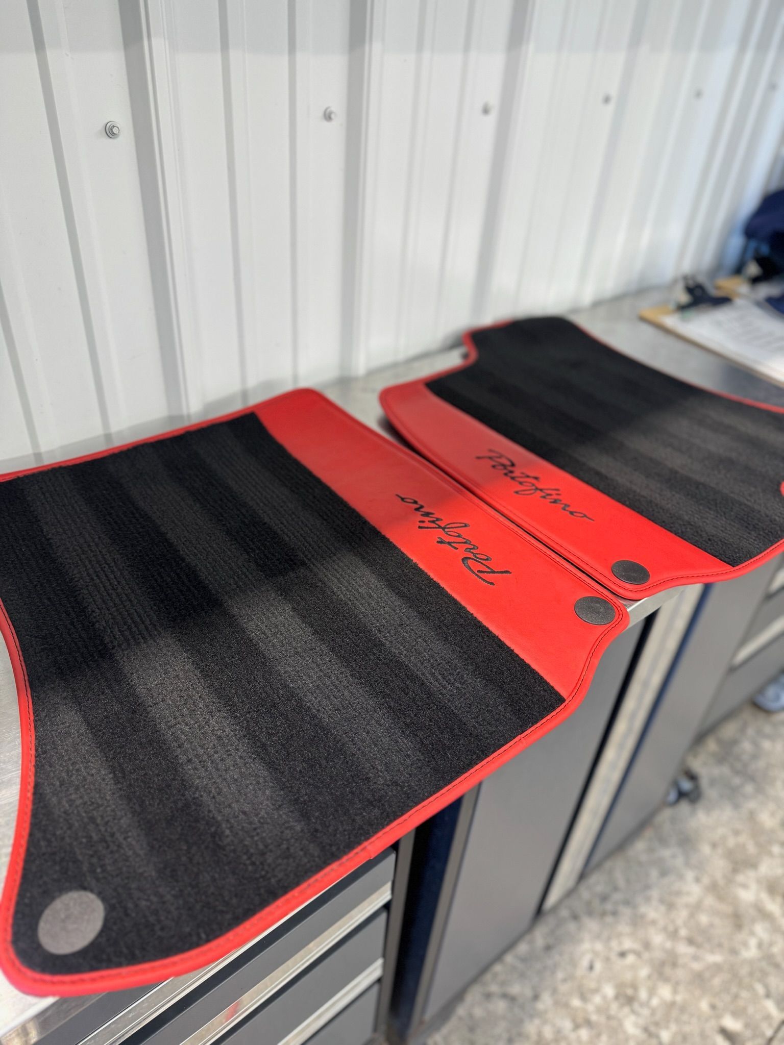 Black and red car floor mats. The mats are striped and have a red border.
