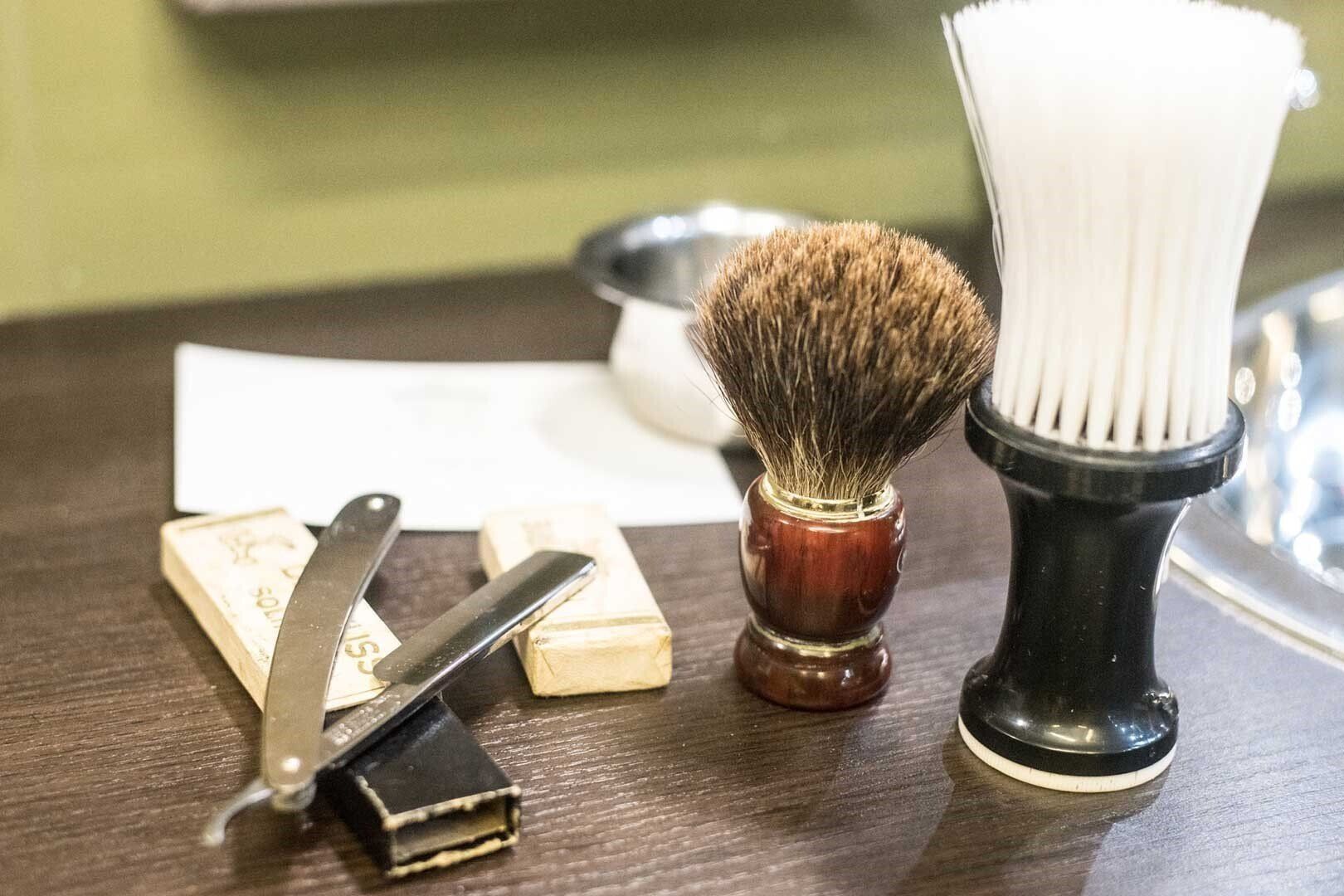 barbiere mentre accorcia la barba a un cliente