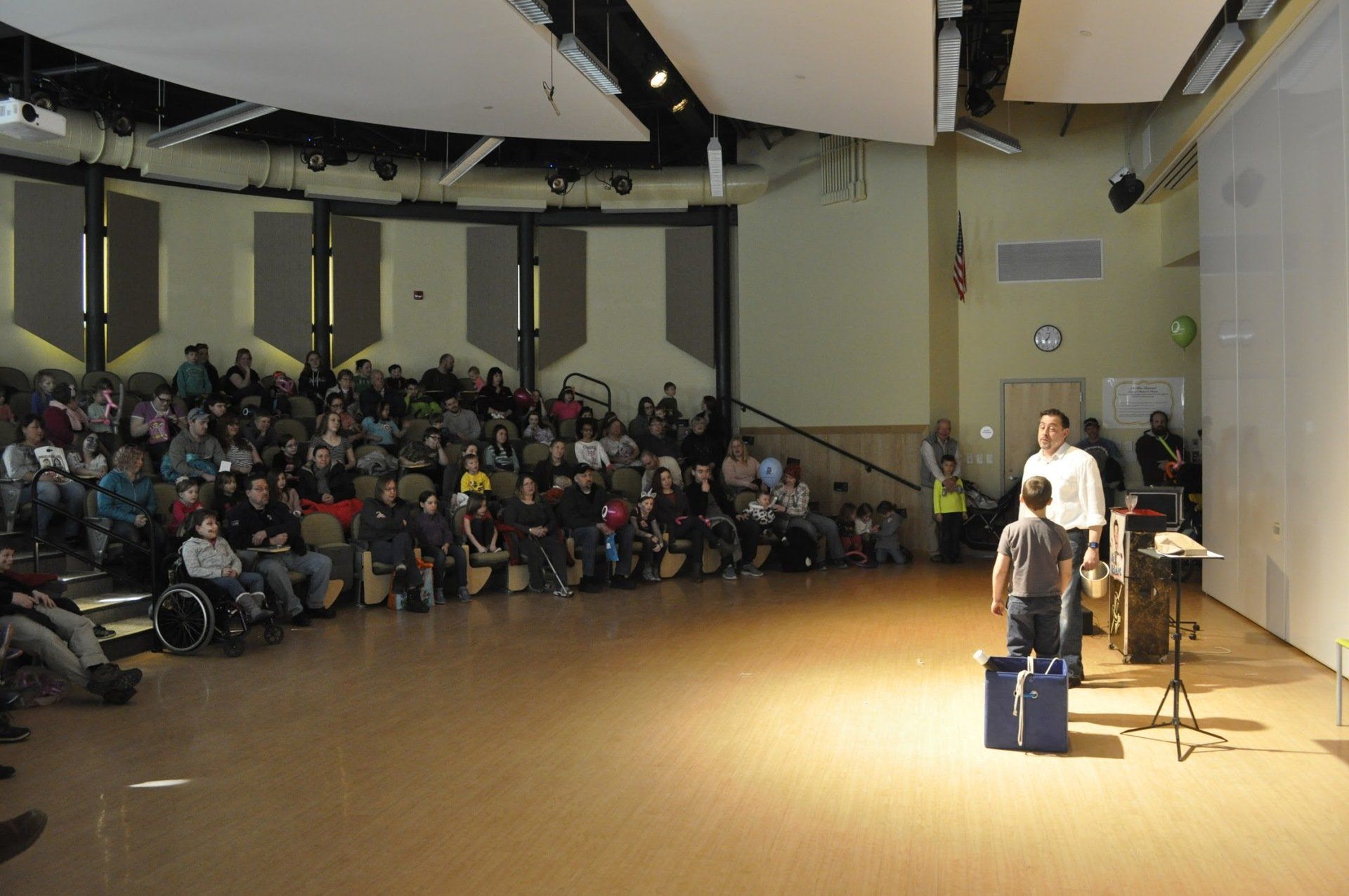 Audience at live public show at family festival and Mr.Magic with a audience volunteer.