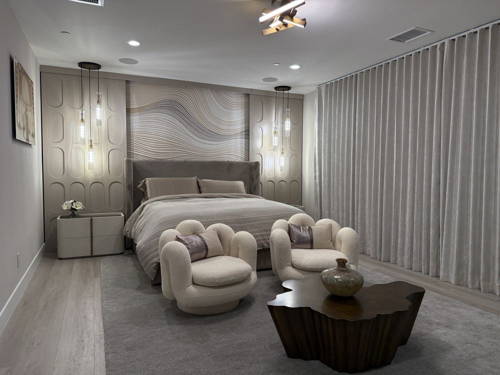 A bedroom with a bed , chairs , and a coffee table.