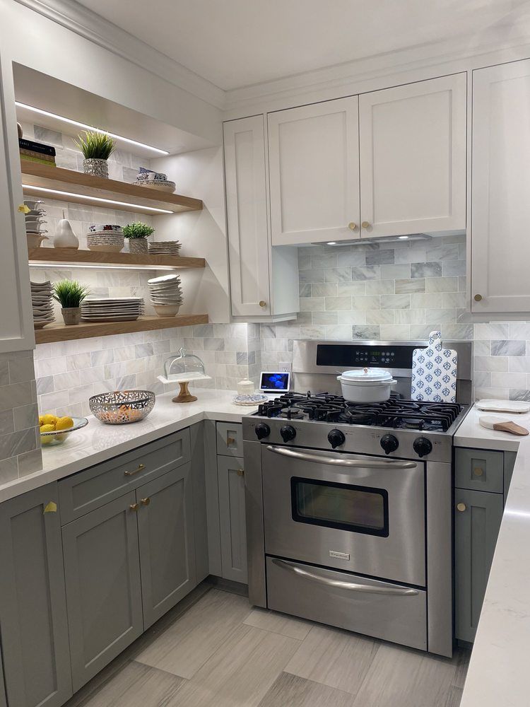 A kitchen with stainless steel appliances and white cabinets.