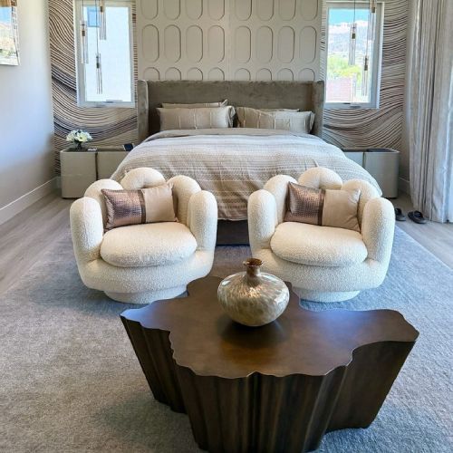 A bedroom with two chairs and a coffee table