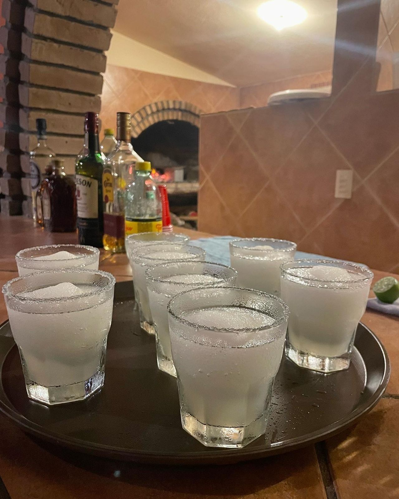 Tray of frosty clear shot glasses on a bar table in a warm restaurant setting