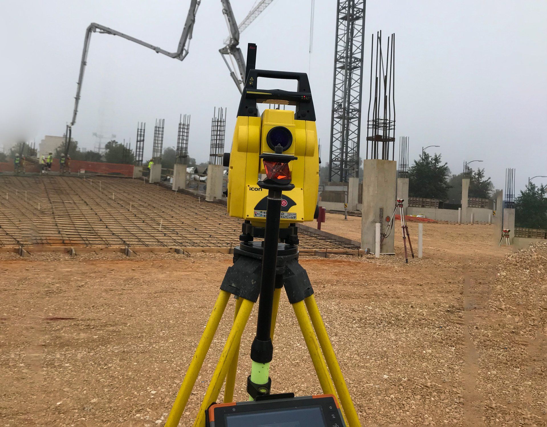 A construction site with a yellow camera on a tripod