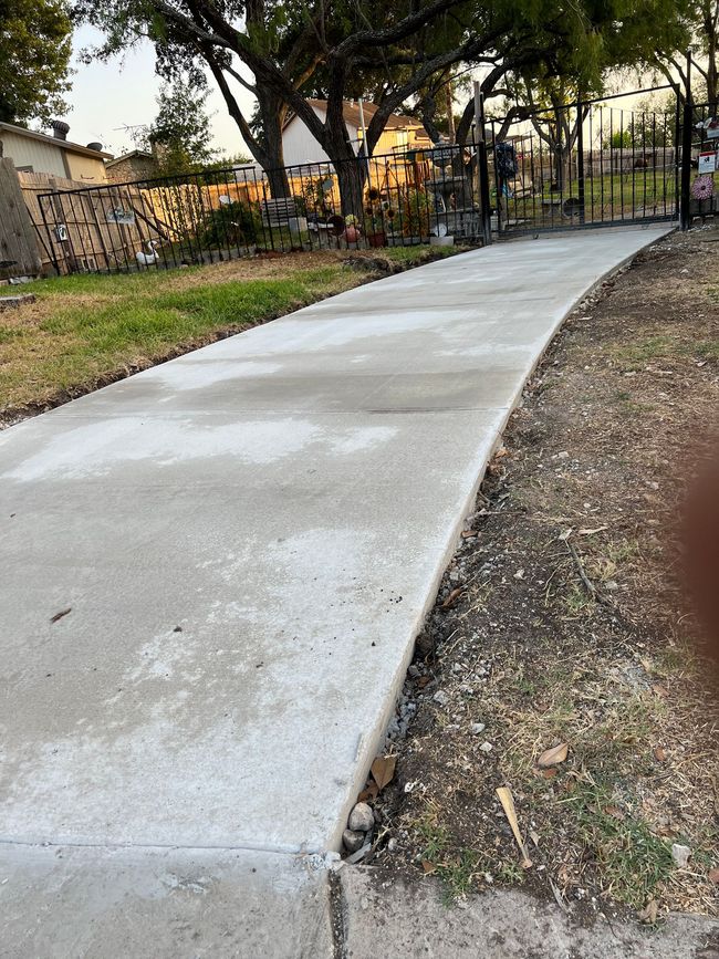 A concrete walkway is being built in a park.