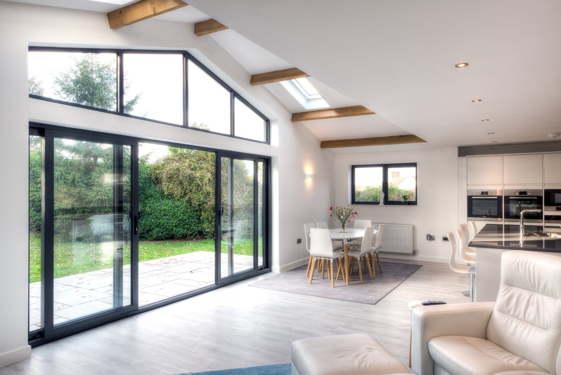 a contemporary architect designed extension to a residential dwelling with exposed beams and feature sliding glass doors