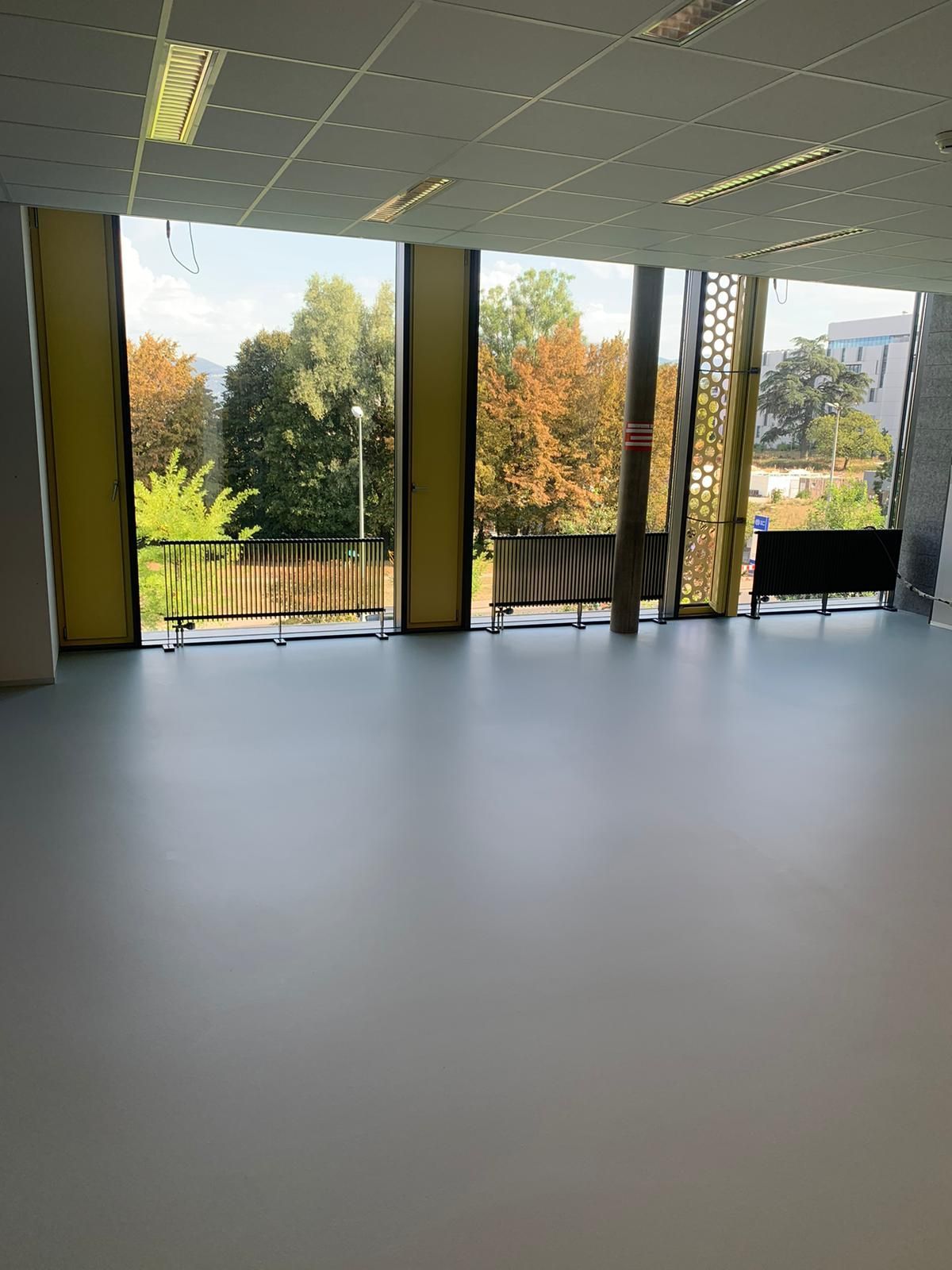 Une grande pièce avec beaucoup de fenêtres et un sol Lino/PVC 