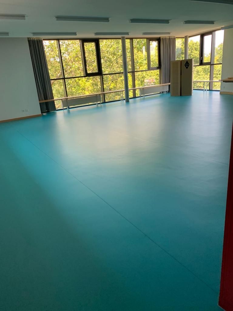 Une grande pièce avec beaucoup de fenêtres et un sol Lino/PVC bleu