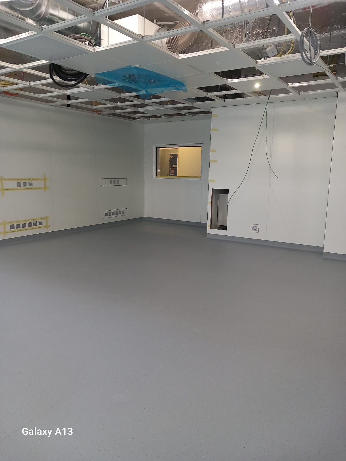 Une grande pièce avec beaucoup de fenêtres et un sol Lino/PVC gris