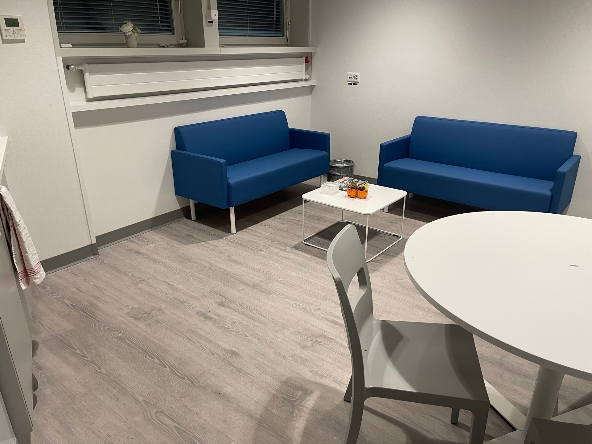 Un salon avec deux canapés bleus et une table blanche