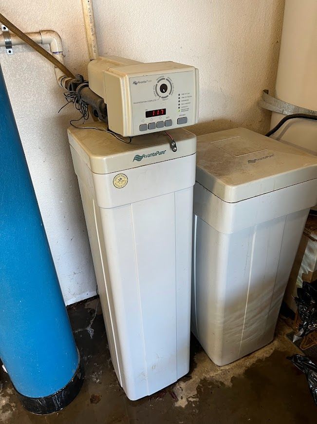 Two water softeners are sitting next to each other in a room.