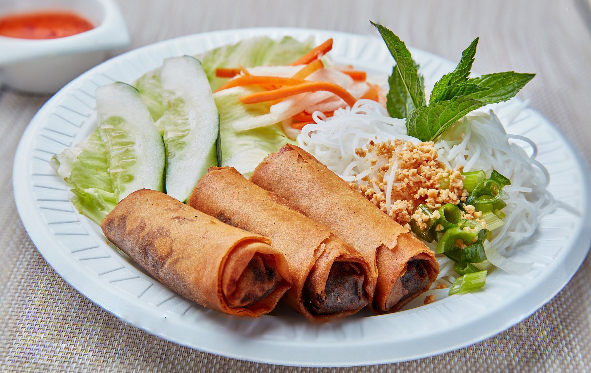 A plate of food with noodles and vegetables on a table.