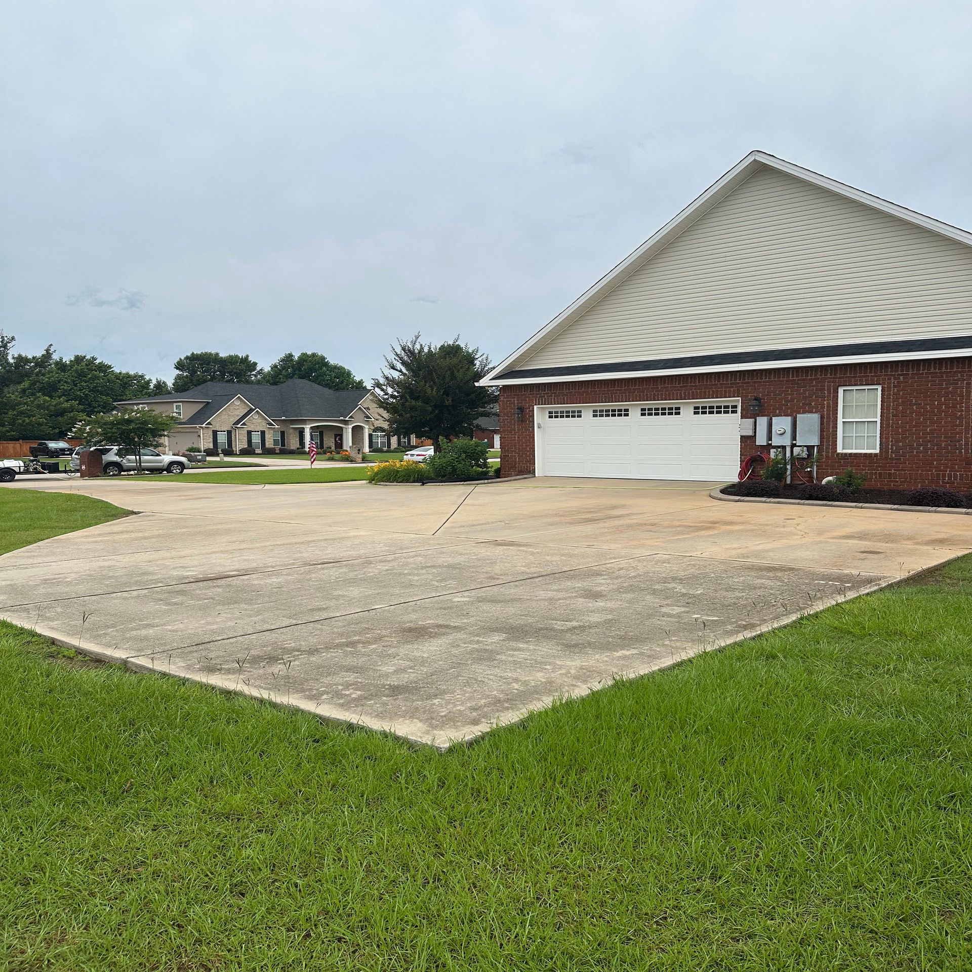 A brick house with a white garage door is in a residential area.