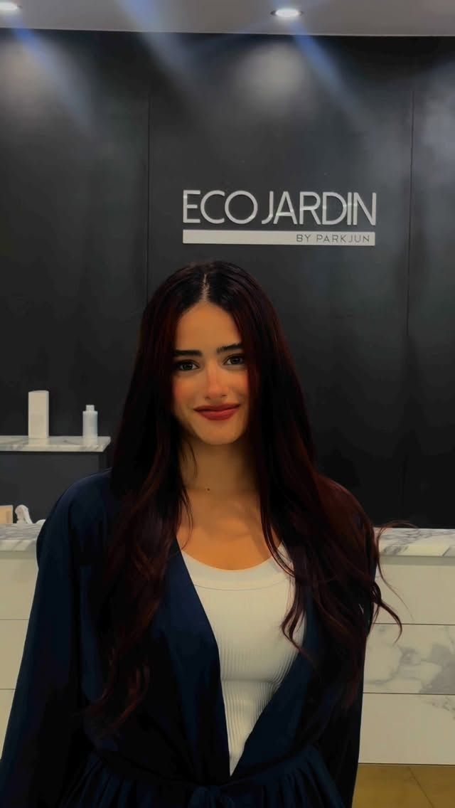 Woman standing in front of an ECOJARDIN sign in a modern indoor lobby.