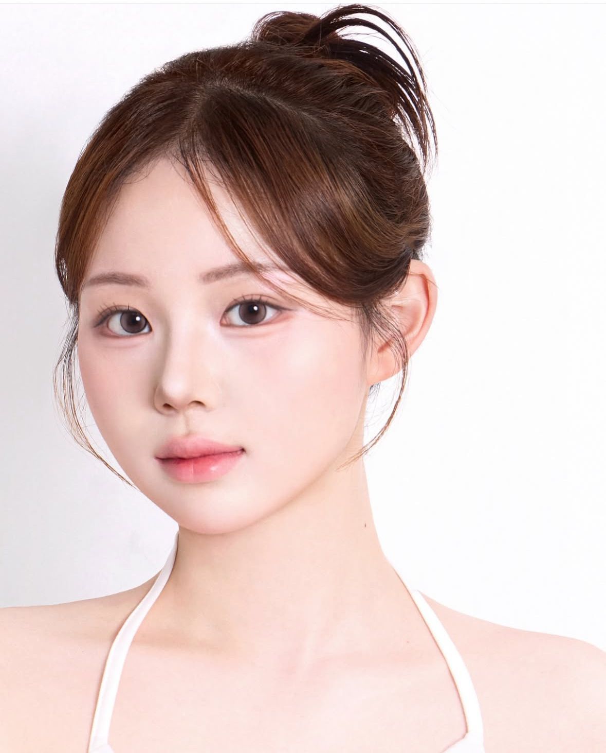 Portrait of a woman with an elegant updo and soft makeup against a white background