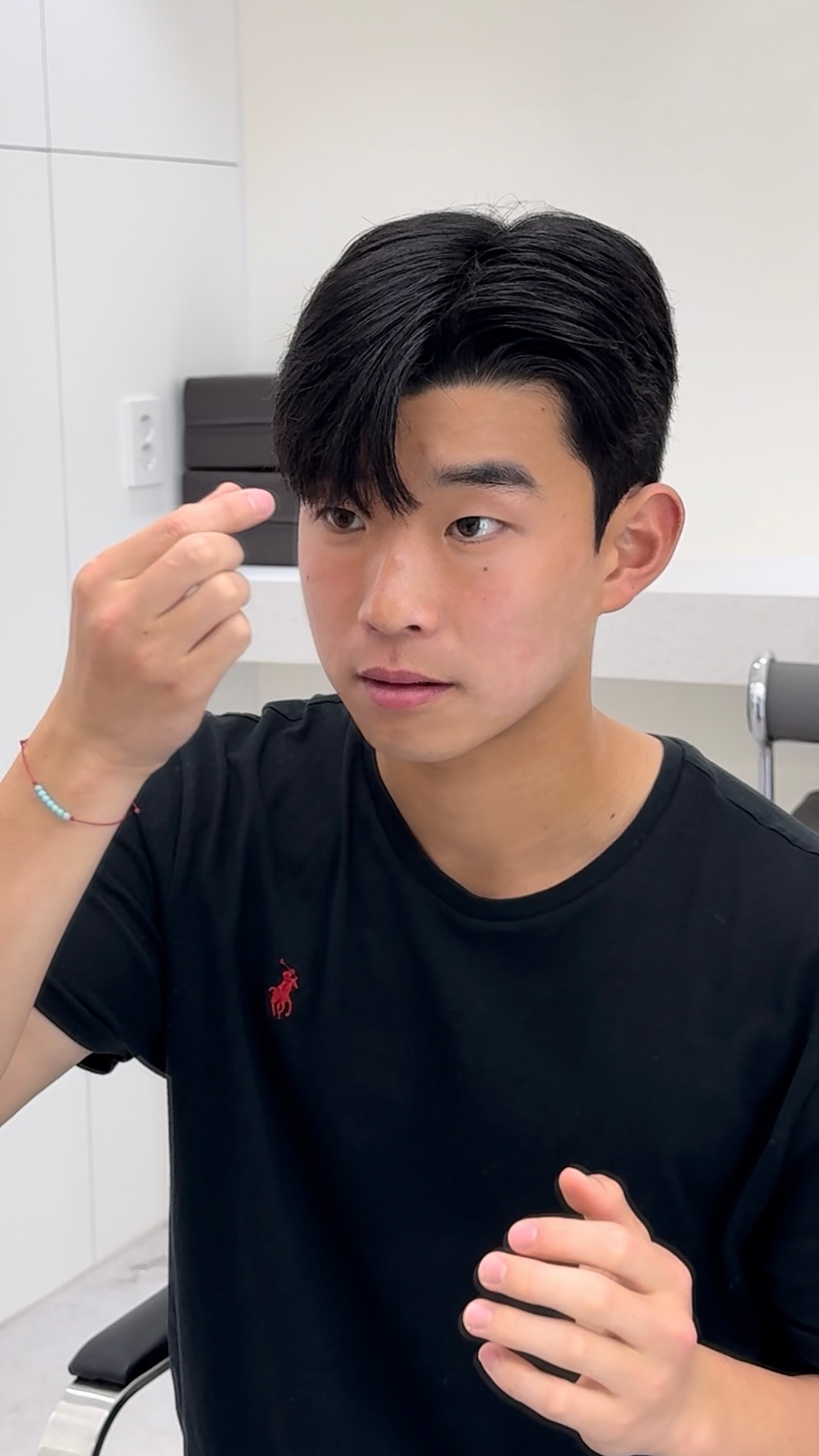 Person using a makeup sponge to touch up their eyebrow in a bathroom mirror.