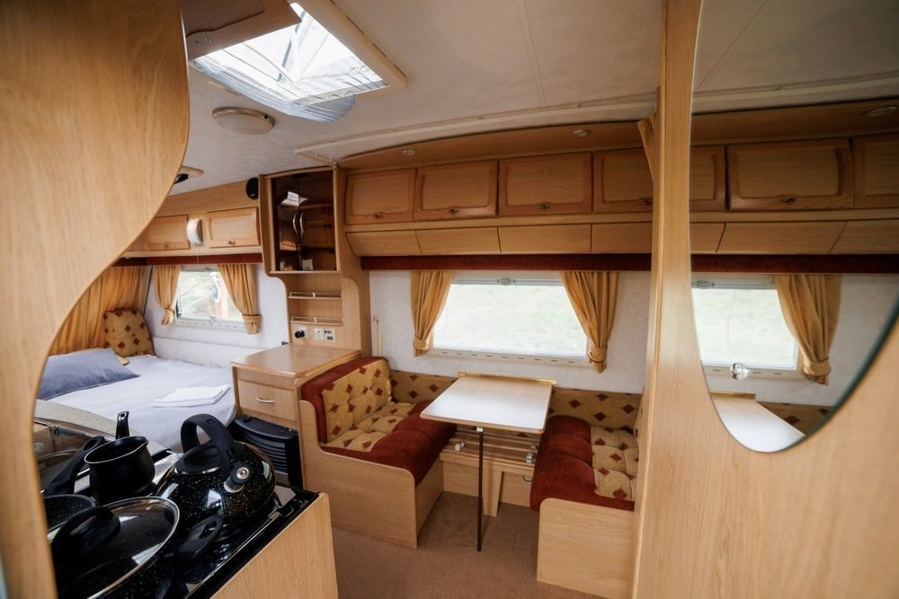 The Inside Of A Camper With A Table And Couch