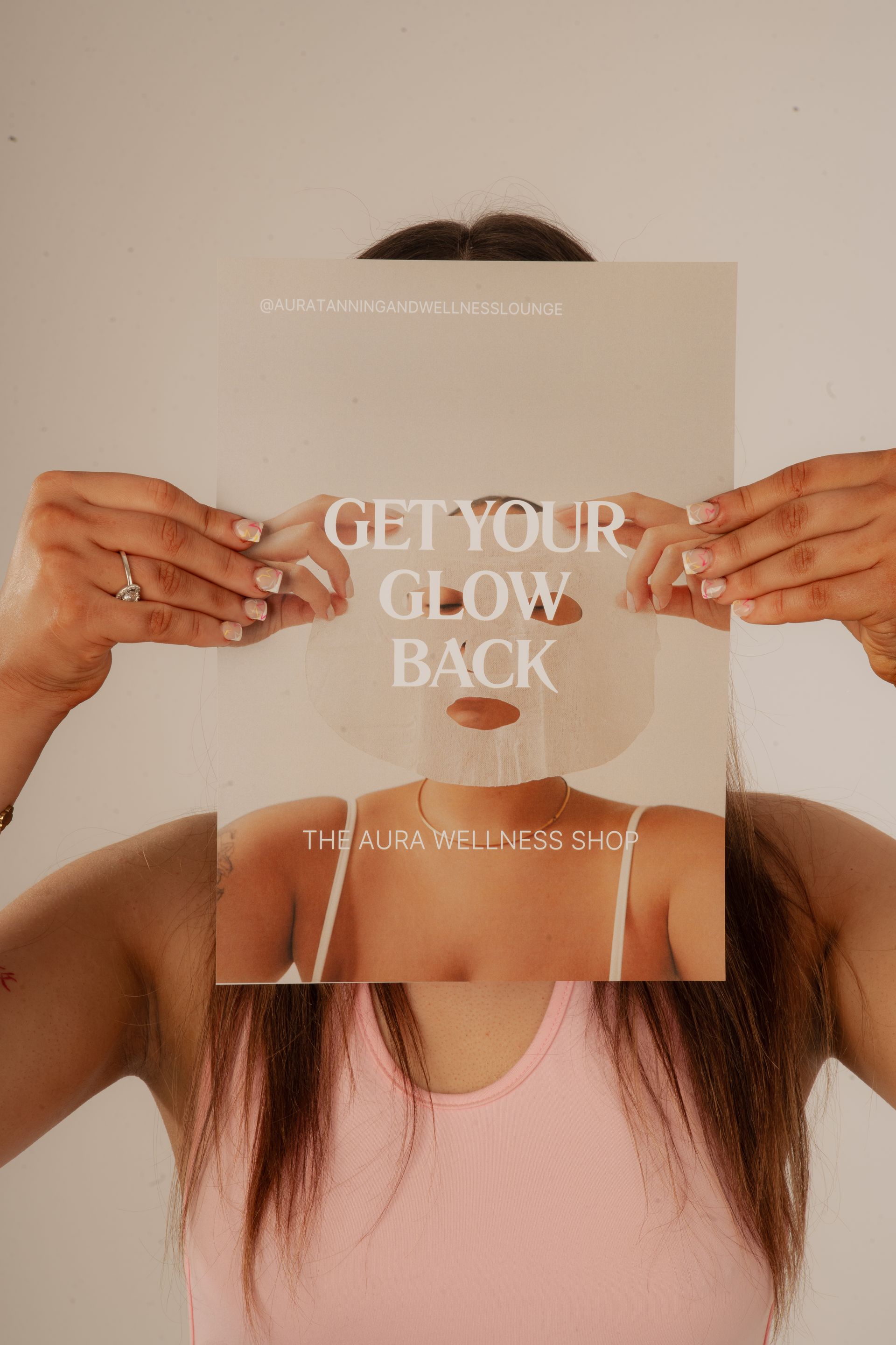 Woman with closed eyes, gently touching cheeks with palms. Skin appears dewy, against a light backdrop.