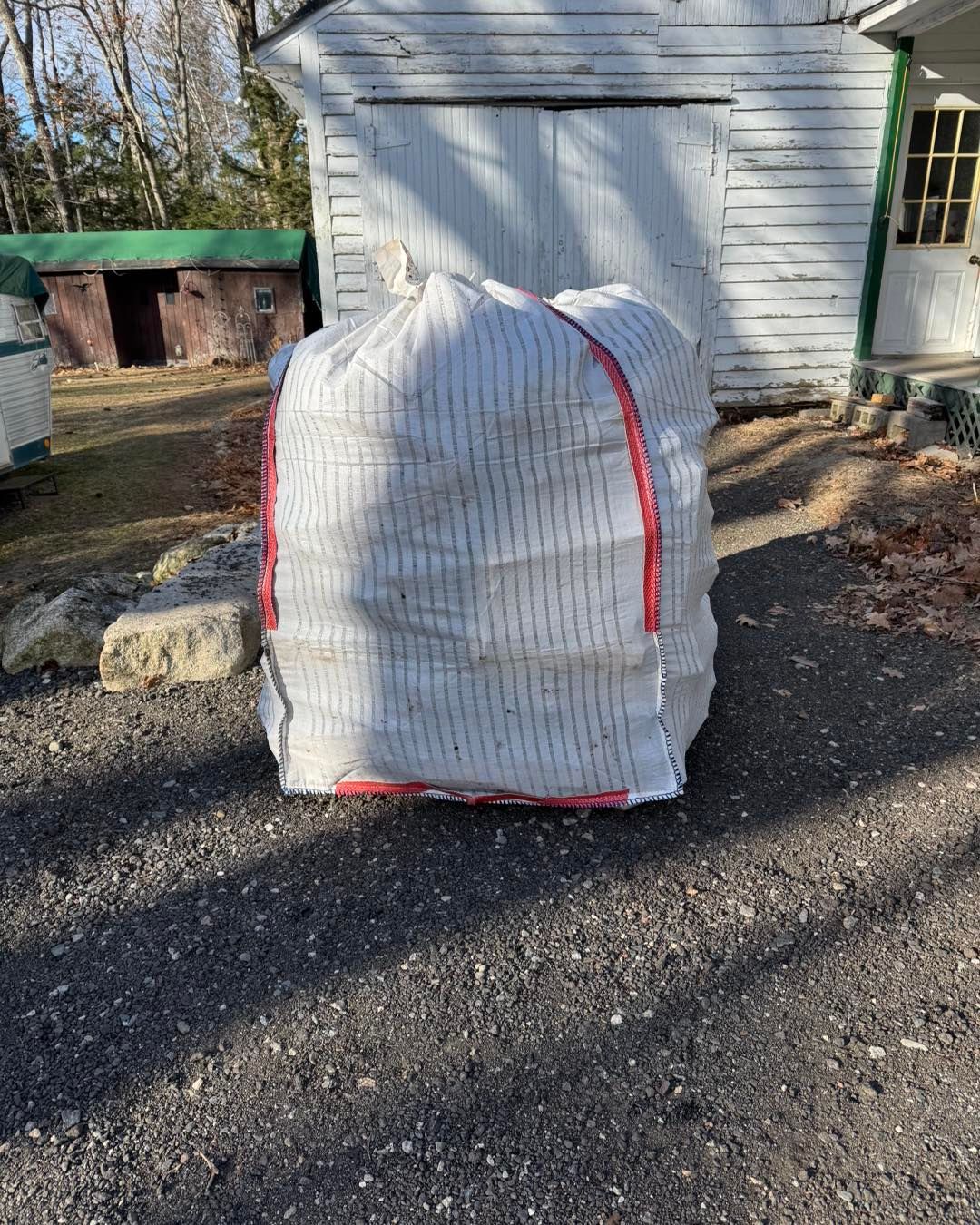 A large white bag is sitting on the side of a road.