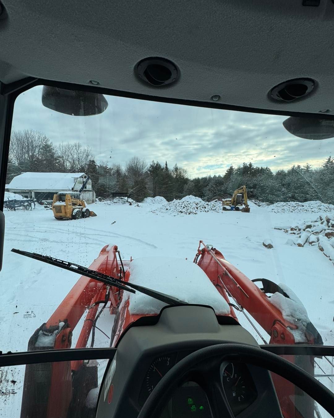 A tractor is driving through a snowy field