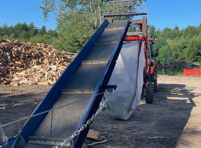 A conveyor belt is attached to the back of a tractor
